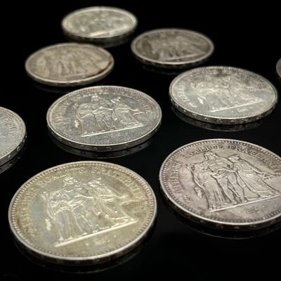 quelques pièces d'argent posées les unes à côté des autres sur une surface noire