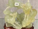 une sculpture en jade vert posée sur un socle, avec une étiquette de prix