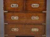 an old wooden chest of drawers with brass hardware on top
