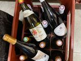 de nombreuses bouteilles de vin dans une boîte rouge posée par terre