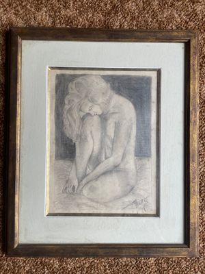 framed drawing of a nude woman sitting on her knees on a brown carpet