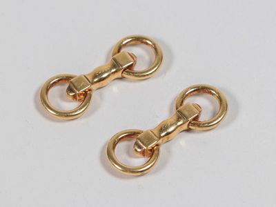 deux paires de fermoirs en métal plaqué or sur un fond blanc