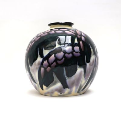 un vase noir et blanc posé sur une surface blanche
