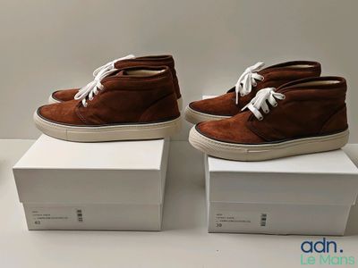 deux paires de chaussures marron sont posées sur des cartons