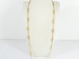 a white mannequin with a gold chain and a long necklace