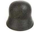 an old black helmet on a white surface with a white background