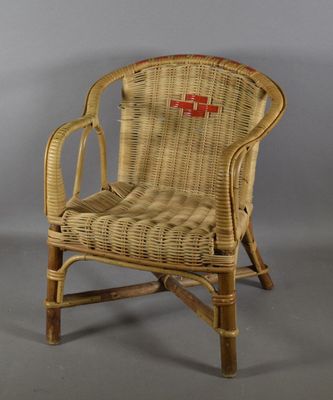 une image représentant une chaise en osier avec une croix rouge sur le dossier