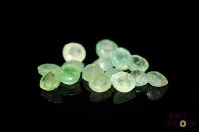 some very pretty green and white stones on a black surface