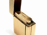 a gold lighter that is sitting on a white surface