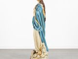 a statue of a woman in blue robe standing on a rock