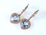 une paire de boucles d'oreilles en topaze bleue et diamants sur fond blanc