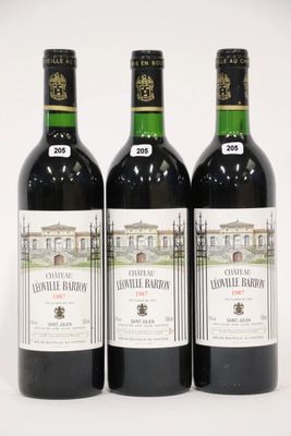 trois bouteilles de vin posées les unes à côté des autres sur une surface blanche