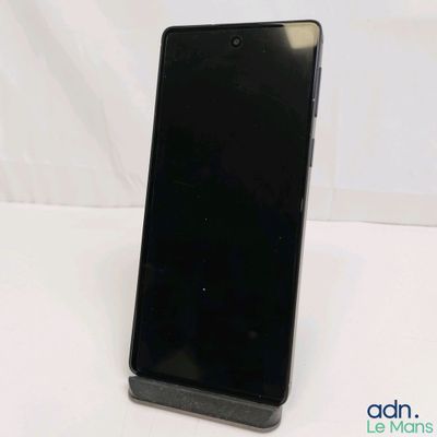 the back of a black cell phone sitting on top of a white table