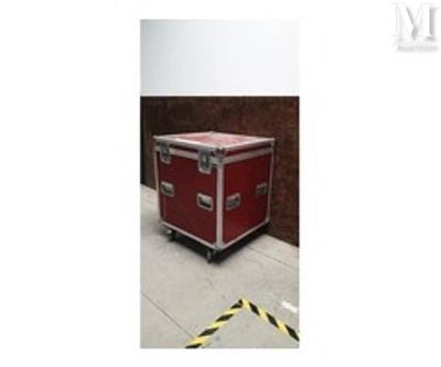 une image montrant une valise rouge posée sur un sol en béton