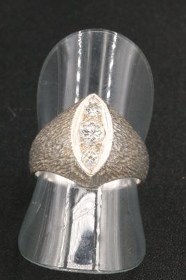 a silver ring with a diamond in it on a black surface