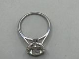 a close up of a diamond ring on a white surface