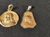 two gold pendants depicting a woman and a man