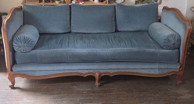 LIT de repos en bois mouluré. Garniture de tissu bleu.