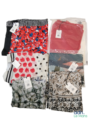 de nombreux types de vêtements différents, rangés dans des sacs, sur un fond blanc