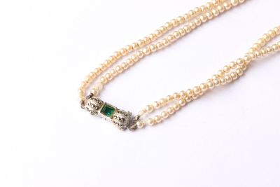 an image of a white pearl necklace with a green stone clasp