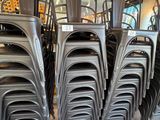 de nombreuses chaises empilées les unes sur les autres dans une pièce