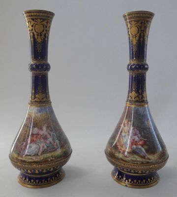 pair of vases with a painting on them sitting on a white surface