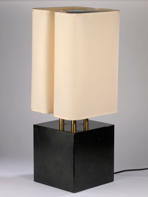 a black table lamp with a white shade on top of it