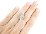 a woman ' s hand with a diamond ring on it