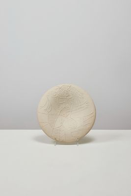 un vase blanc posé sur une table près d'un mur blanc