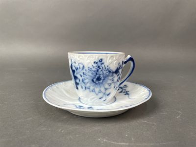 a blue and white cup and saucer sitting on a table