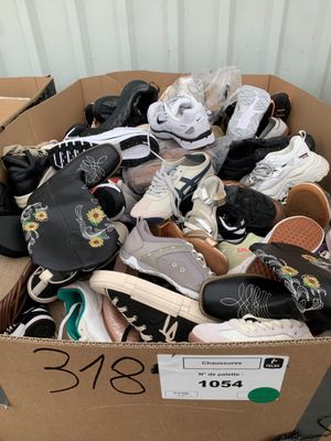 plusieurs paires de chaussures dans une boîte en carton posée sur le sol