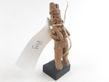figurine en bois représentant un homme tenant un morceau de papier sur un socle