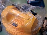 a yellow telephone sitting on top of a plastic bag