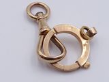 a close up of a gold charm on a white surface
