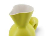 un vase jaune posé sur une surface blanche