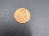 gros plan d'une pièce d'or sur une surface noire