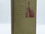 an old book sitting on top of a table on a white surface