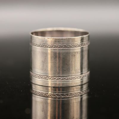 a close up of a silver ring on a black surface