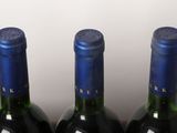 four bottles of wine are lined up in a row