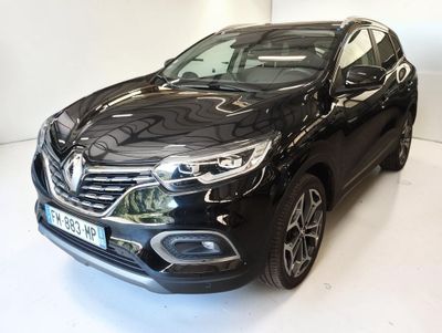 La voiture noire est garée sur le sol blanc de la pièce.