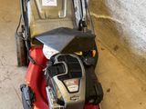 une image d'une tondeuse à gazon garée dans un garage