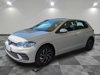 une Volkswagen Golf blanche garée dans une pièce au sol carrelé