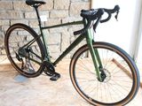a green bike parked in front of a brick wall