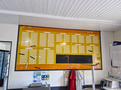 a yellow and black menu board on the wall in the kitchen
