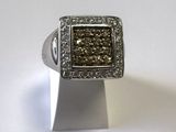 bague en argent sertie de diamants bruns et blancs sur un fond blanc
