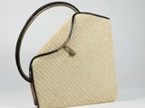a close up of a straw bag with a handle on a white background