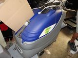 un homme qui se tient à côté d'une machine bleue