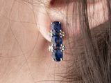 a close up of a woman ' s ear with a pair of earrings on it
