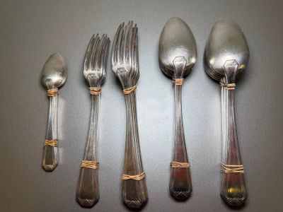 five silver spoons and two silver spoons on a table