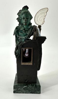 statue d'un homme assis sur un socle, tenant un miroir à la main
